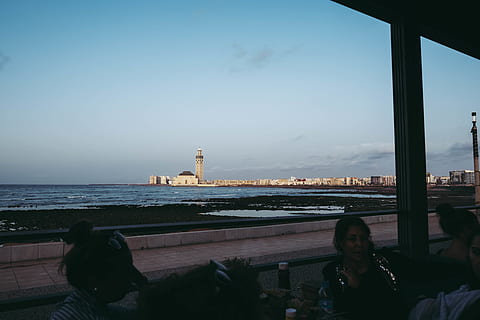 white, lighthouse, surrounded, body, water, architecture, beach, clouds, daytime, landscape, nature, ocean, people, sand, sea, seascape, seashore, sky, built structure, building exterior, tower, building, guidance, city, outdoors, window, men, day, protection, railing, security, 5K, CC0, public domain, royalty free