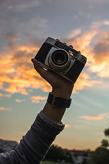 vecchio, telecamera, conservare, braccio, Alba, foto, retrò, fotografia, fotografo, Vintage ▾, nostalgia, viaggio, antico, ragazza, lente, tecnologia, grilletto, immagini, classico, film, fotografie, attrezzatura, tramonto, cielo, detenzione, mano, nuvola - cielo, mano umana, una persona, colore arancione, temi fotografici, natura, prospettiva personale, persone reali, parte del corpo umano, concentrarsi sulle conoscenze acquisite, stili di vita, persona irriconoscibile, avvicinamento, macchina fotografica - attrezzatura fotografica, all'aperto, arto umano, Camera digitale, 5K, CC0, dominio pubblico, privo di copyright