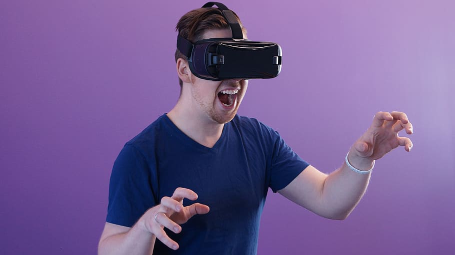 vr, Virtual reality, mand, teknologi, blå skjorte, HMD, headset, oculus, beskyttelsesbriller, futuristisk, erfaring, innovation, virtual reality simulator, menneskelig kropsdel, studio skud, en person, briller, indendørs, voksen, gestikulerer, menneskelig hånd, smilende, kunstkultur og underholdning, hånd, trådløs teknologi, cyberspace, munden åben, farvet baggrund, mund, 3-d briller, tredimensionale, spænding, menneskelige arm, 4K