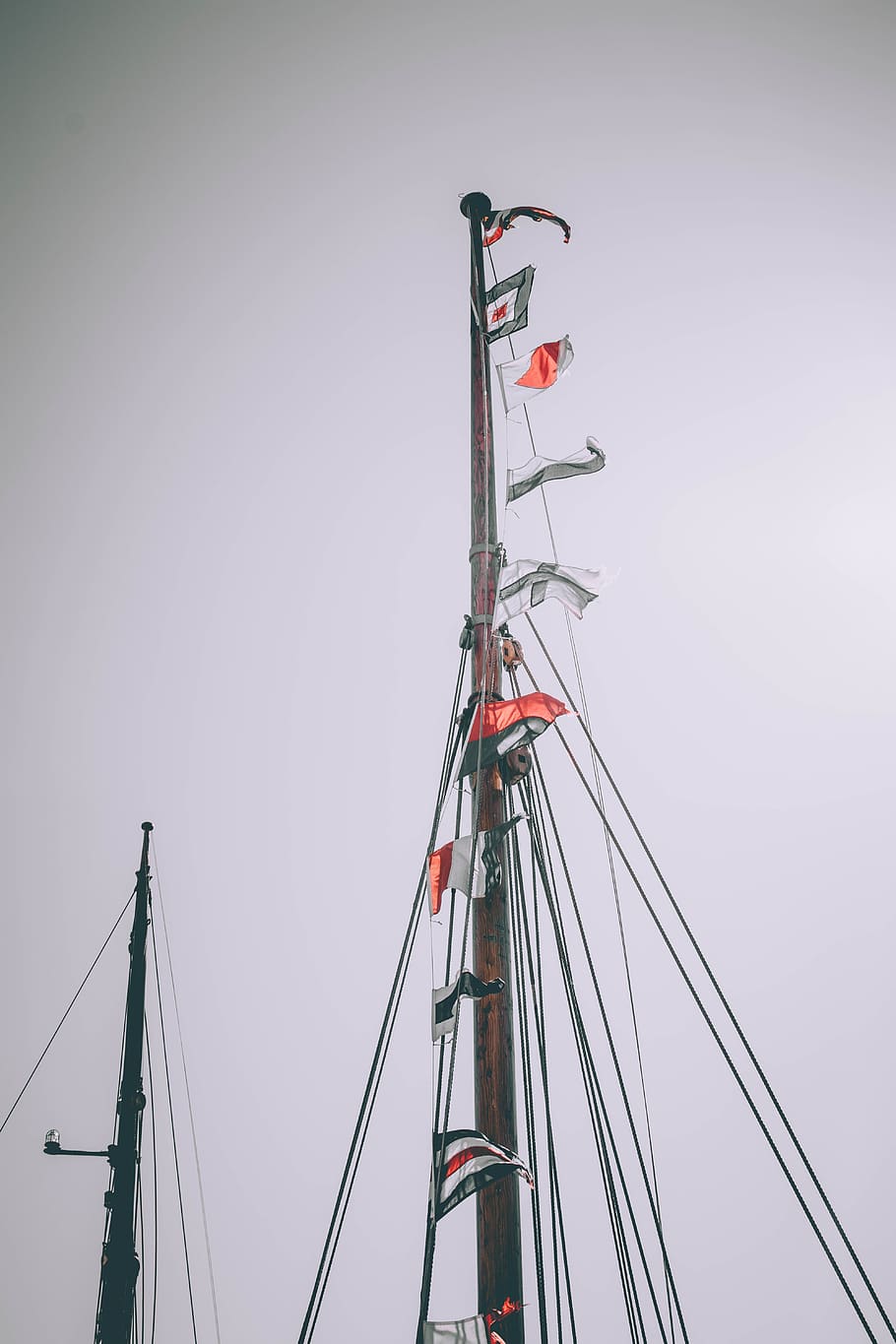 brauner Strommast, Transport, Schiff, Fahrzeug, Wasserfahrzeug, Flagge, Boot, Hafen, Ufergegend, Seebrücke, Wasser, Dock, fliegende Fahnen, ungesättigt, rot, ausgewählte Farbe, Flaggen, retro, Nationalflaggen, fremd, Film, Himmel, klarer Himmel, Flachwinkelansicht, Natur, Pole, Mast, Tag, keine Leute, Segelboot, Verbindung, kopieren sie platz, draußen, Transportmittel, Kabel, Seil, Metall, gebaute Struktur, hoher Abschnitt, Takelwerk, 5K