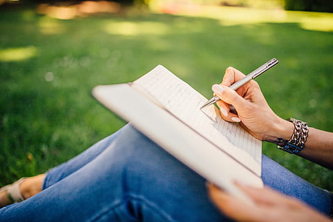 writing, writer, notes, pen, notebook, book, girl, woman, people, hands, grass, outdoors, human hand, hand, human body part, one person, holding, adult, casual clothing, day, park, young adult, publication, lifestyles, leisure activity, activity, relaxation, studying, note pad, 5K