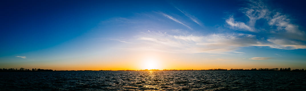sunset over sea, clouds, panorama, panoramic, sky, sunset, water, horizon, tranquility, sea, cloud - sky, blue, scenics - nature, tranquil scene, sunlight, urban skyline, nature, beauty in nature, sun, no people, dramatic sky, sunbeam, horizon over water, dark, outdoors, 8K, CC0, public domain, royalty free
