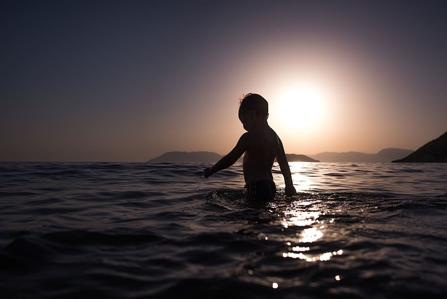 nen, banyar-se, oceà, mar, silueta, llum de fons, tarda, posta de sol, noi, feliç, infància, poc, diversió, bonic, estiu, festa, vacances, a l'aire lliure, oci, reflexió, aigua, cel, una persona, bellesa a la natura, davant del mar, escenics - natura, activitat d'oci, persones reals, estils de vida, naturalesa, cel clar, horitzó sobre l’aigua, color taronja, tranquil·litat, escena no urbana, sol, 5K