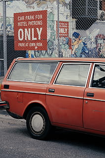 station wagon rossa, auto, ruota, automobile, mezzi di trasporto, veicolo, umano, persona, pneumatico, città, berlina, testo, graffiti, finestra, macchina, ha parlato, cartello, recinto, ruota in lega, ruota di automobile, retrò, modo di trasporto, architettura, esterno dell'edificio, veicolo a motore, struttura costruita, giorno, strada, veicolo terrestre, rosso, nessuno, comunicazione, sceneggiatura occidentale, all'aperto, parete, 2K, CC0, dominio pubblico, privo di copyright