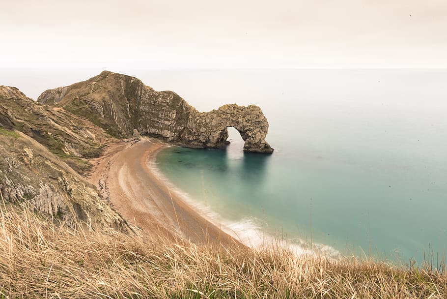 formació de roca marró, aigua, línia de costa, mar, naturalesa, a l'aire lliure, oceà, Costa, cova, cala, terra, promontori, s camí de la costa, dorset, Regne Unit, platja, península, penya-segat, badia, paisatge, bellesa a la natura, escenics - natura, escena tranquil·la, tranquil·litat, escena no urbana, rock, cap gent, dia, cel, idíl·lic, arc natural, rock - object, formació de roca, herba, erosionat, 5K