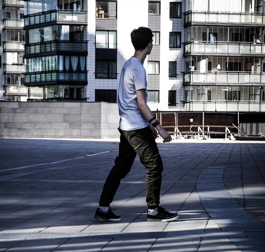 hombre, para caminar, gris, pavimento de ladrillo, blanco, edificio, persona, humano, gente, urbano, ciudad, en pie, azulejo, masculino, adolescente, moderno, niño, vestir, ropa, alojamiento, retrato, cara, actividades de ocio, una persona, estructura construida, arquitectura, gente real, ropa casual, exterior del edificio, hombres, longitud total, día, actividad de ocio, estilos de vida, vista lateral, jóvenes, luz del sol, al aire libre, deporte, 2K