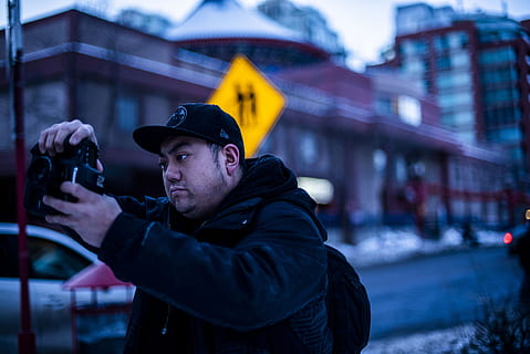 Mann, der Kamera hält, Person, Mensch, bekleidung, Hut, Kleidung, Foto, Fotografie, Waffe, Waffen, Gewehr, Deckel, Fotograf, Beleuchtung, Symbol, Stativ, Gesicht, Mantel, Zubehörteil, Brille, Zubehör, eine Person, halten, Taille hoch, Männer, die Architektur, Technologie, echte Menschen, Gebäudehülle, Stehen, Porträt, Erwachsene, Fokus auf den Vordergrund, Fotografie-Themen, junger Erwachsener, warme Kleidung, draußen, 5K, CC0, gemeinfrei, lizenzfrei