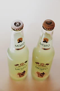 two mojito bottles, beverage, drink, alcohol, bottle, liquor, sake, milk, plant, beer, beer bottle, lemonade, soda, produce, citrus fruit, fruit, grapefruit, food, gin, bread, bun, indoors, text, container, close-up, western script, no people, still life, communication, studio shot, white background, food and drink, high angle view, two objects, label, table, focus on foreground, variation, refreshment, 5K, CC0, public domain, royalty free