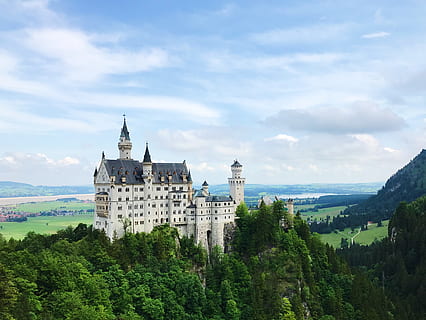white, castle, surrounded, trees, architecture, clouds, daylight, fortification, landmark, landscape, mountain, sky, towers, tree, building exterior, built structure, plant, building, cloud - sky, nature, no people, day, growth, green color, beauty in nature, history, the past, travel destinations, tower, outdoors, 2K, CC0, public domain, royalty free