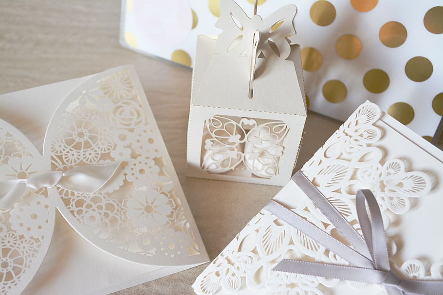 carpeta de cordons blancs, talla, disseny, elegant, invitacions, celebració, a l'interior, patró, taula, cinta: objectes de cosir, vista d’angle alt, cap gent, Color blanc, natura morta, esdeveniment, cinta, art i artesania, regal, primer pla, arc, llaç de llaç, decoració, paper, contenidor, caixa-contenidor, motiu floral, luxe, 5K