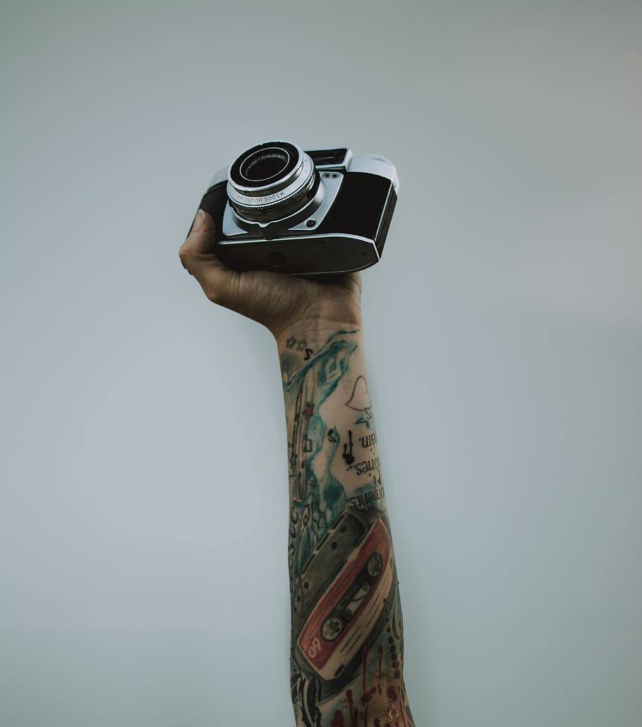 persona, celebració, càmera slr, art, càmera, primer pla, electrònica, equipament, mà, a l'interior, lent, modern, estudi, tatuatges, tecnologia, tir de l'estudi, tatuatge, una persona, càmera - equip fotogràfic, temes de fotografia, fons gris, part del cos humà, còpia espai, gris, creativitat, metall, estils de vida, perspectiva personal, adult, 4K