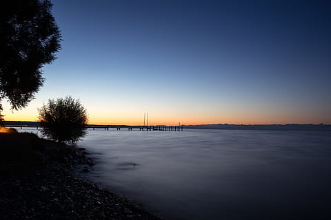 Alemanya, bodensee, aigua, cel, posta de sol, escenics - natura, bellesa a la natura, arbre, naturalesa, tranquil·litat, cap gent, planta, escena tranquil·la, silueta, arquitectura, pont, color taronja, pont - estructura feta per l'home, connexió, cel clar, transport, a l'aire lliure, 8K, CC0, domini públic, lliure de regalies
