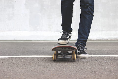 man riding skateboard, apparel, clothing, shoe, footwear, skateboard, sport, person, human, sports, jeans, pants, highway, vans, youth, sneakers, street, shoes, denim, tarmac, asphalt, low section, human leg, body part, road, human body part, one person, real people, city, day, lifestyles, standing, transportation, outdoors, road marking, casual clothing, symbol, leisure activity, human foot, human limb, 5K, CC0, public domain, royalty free