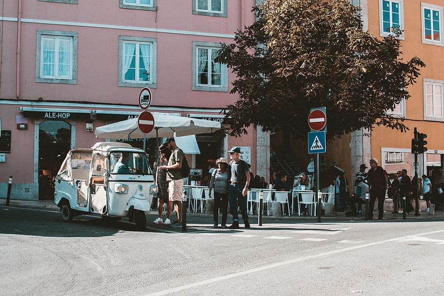 gent, carrer, blanc, rickshaw automàtic, arquitectura, cadires, comerç, multitud, la llum del dia, homes, paviment, carretera, senyalització, turisme, ciutat, senyal de trànsit, sistema de transport, arbre, urbà, vehicle, caminar, finestres, transport, exterior de l'edifici, grup de persones, manera de transport, estructura construïda, vehicle terrestre, persones reals, cotxe, automòbil, vida de ciutat, carrer de la ciutat, dia, estils de vida, a l'aire lliure, govern, 5K