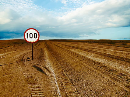 100 speed, limited, barren, area, clouds, desert, dry, empty, environment, nature, road sign, sand, scenic, sky, soil, cloud - sky, sign, road, land, communication, landscape, transportation, scenics - nature, day, no people, horizon over land, tranquil scene, field, beauty in nature, horizon, tranquility, outdoors, arid climate, 4K, CC0, public domain, royalty free