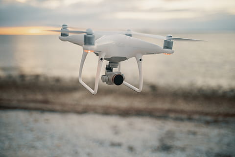 flying, white, quadcopter drone, camera, drone, technology, transportation, mid-air, air vehicle, motion, airplane, no people, mode of transportation, sky, nature, focus on foreground, surveillance, speed, airport runway, day, hovering, landing - touching down, military, sea, aerospace industry, aggression, 5K, CC0, public domain, royalty free