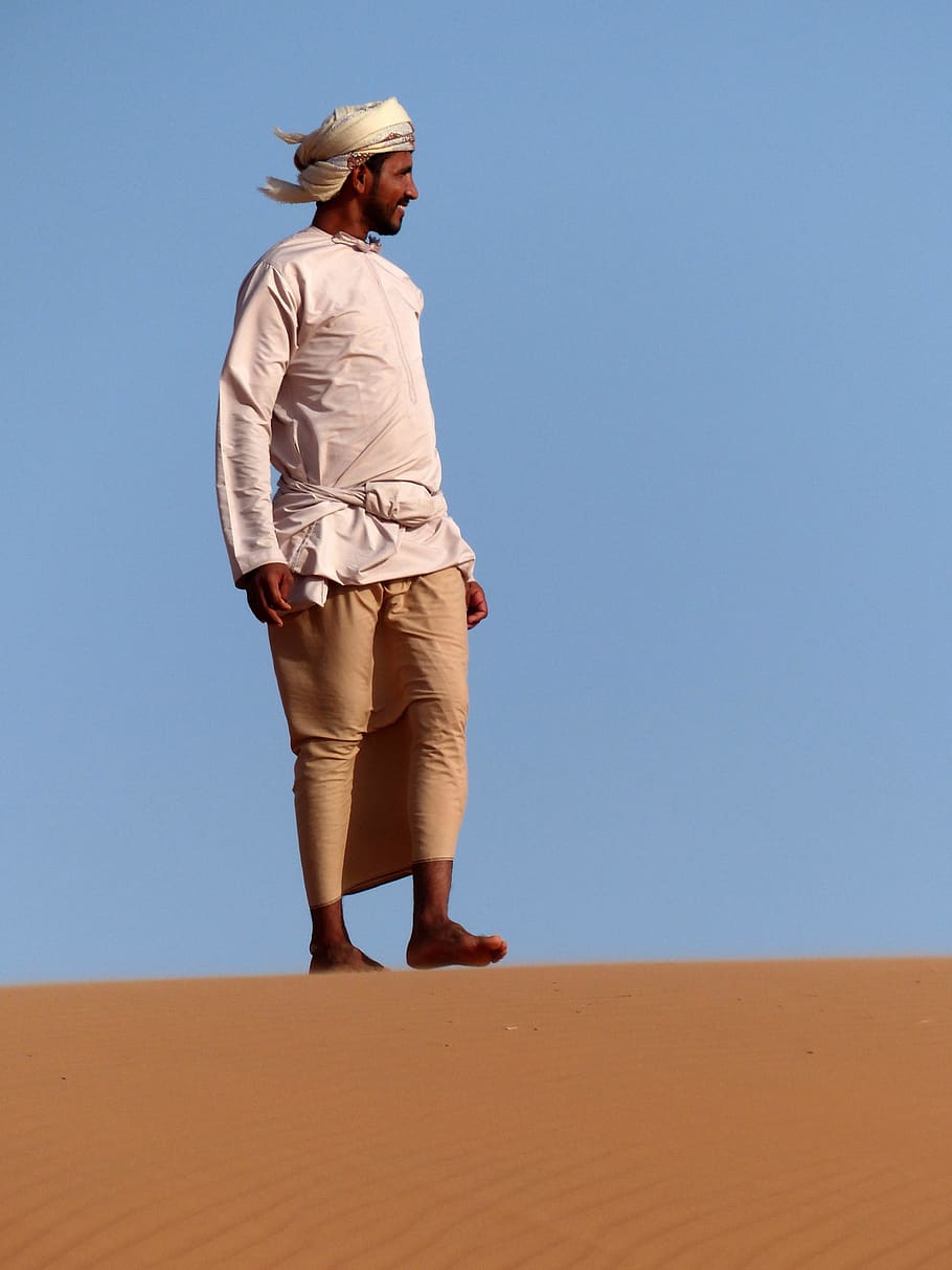 duna, sorra, home, desert, paisatge, beduino, oman, una persona, terra, cel, longitud completa, cel clar, roba, persones reals, roba casual, naturalesa, dia, de peu, estils de vida, barret, activitat d'oci, còpia espai, caminar, adult, clima àrid, clima, 4K
