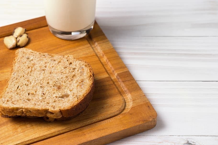 rodanxa de pa de blat, marró, fusta, pissarra, al forn, pa, primer pla, alba, beure, menjar, vidre, salut, saludable, casolà, a l'interior, llet, tall, blat, menjar i beguda, producte diari, taula de tallar, material de fusta, refresc, frescor, alimentació saludable, benestar, equipament per a la llar, esmorzar, taula, copa, cap gent, berenar, pa marró, ganivet de taula, picat, 5K