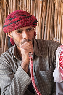 mand bruger hookah, beklædning, tøj, hat, human, person, mand, ansigt, binde, tilbehør, han-, tørklæde, røg, pandebånd, rør, shisha, mode, stil, hånd, holde, en person, portræt, voksen, kigger på kameraet, strik hat, hovedskud, forfra, bedrift, ansigtshår, skæg, herrer, moden voksen, midt voksen, beskæftigelse, dag, tæt på, overvejelse, 5K, CC0, offentligt domæne, royaltyfrie
