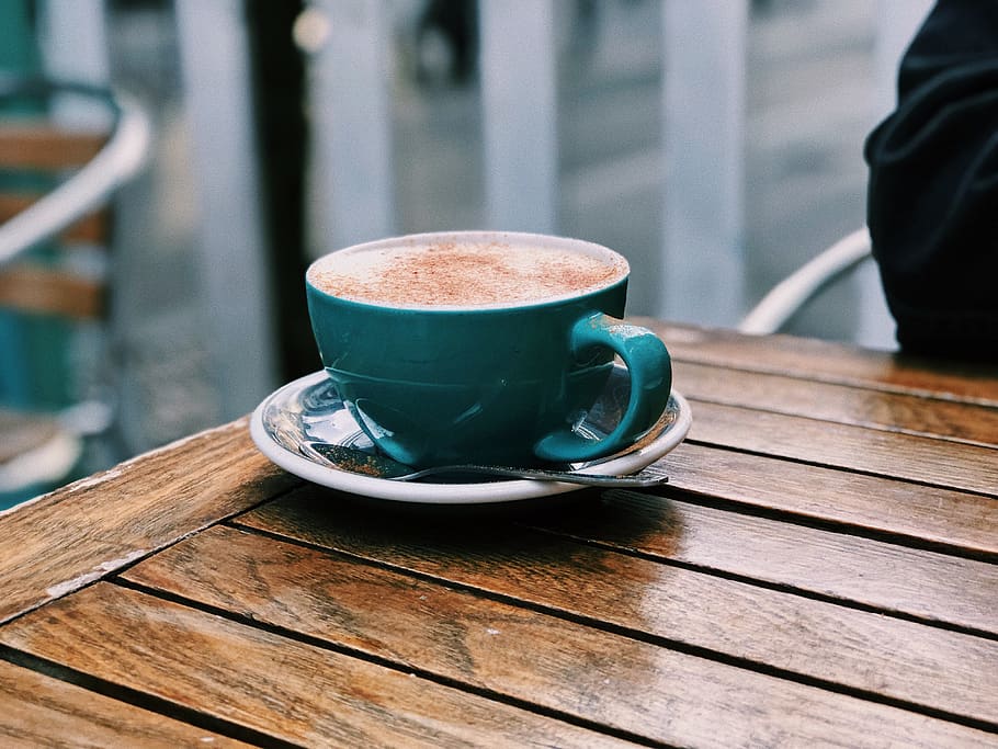 blau, ceràmica, tassa de te, taula, tassa, plat, tassa de cafè, humà, persona, chai latté, cafè, taula de fusta, fusta, beure, begudes, latte, mobles, taula de cafè, restaurant, cafeteria, aigua, cafè - beguda, refresc, menjar i beguda, material de fusta, vaixella, utensili per menjar, natura morta, primer pla, cullera, centrar-se en primer pla, frescor, dia, beguda calenta, beguda espumosa, begudes sense alcohol, cafeïna, 4K