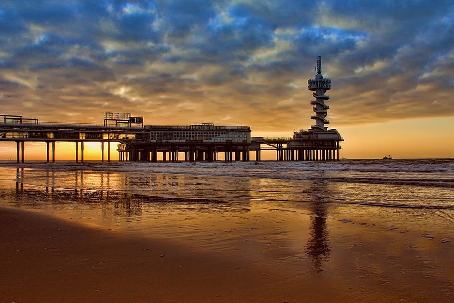 edifici de formigó negre, platja, núvols, alba, oceà, núvol, moll, reflexió, sorra, mar, paisatge marí, vora del mar, Riba, sortida del sol, posta de sol, aigua, arquitectura, cel, estructura construïda, núvol - cel, destinacions de viatge, naturalesa, exterior de l'edifici, viatjar, terra, torre, cap gent, turisme, a l'aire lliure, escenics - natura, 720P
