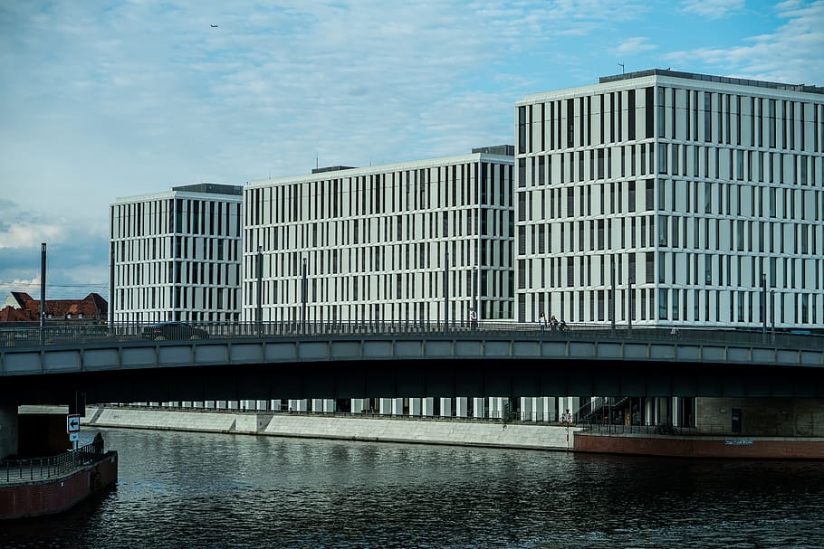 edifici de formigó gris, edifici, edifici d'oficines, pont, arquitectura, ciutat, metròpolis, urbà, aigua, davant del mar, transport, vaixell, vehicle, paisatge urbà, Berlín, paisatge, humà, persona, arquejat, estructura construïda, exterior de l'edifici, cel, núvol - cel, modern, naturalesa, exterior d’edifici d’oficines, dia, cap gent, reflexió, riu, oficina, a l'aire lliure, gratacels, 5K