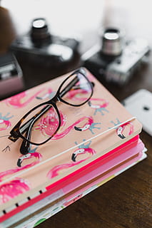 pink calendar, calendar, notebook, diary, note, desk, table, eyeglasses, indoors, glasses, pink color, still life, close-up, high angle view, no people, focus on foreground, technology, pen, office, personal accessory, connection, equipment, selective focus, paper, communication, 4K, CC0, public domain, royalty free