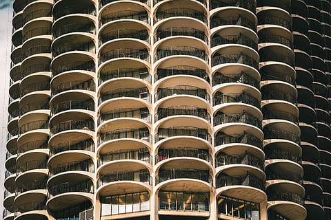 brown concrete building, furniture, chair, building, housing, condo, high rise, city, town, urban, home decor, apartment building, office building, handrail, banister, window, undershirt, apparel, clothing, linen, architecture, backgrounds, built structure, pattern, no people, repetition, in a row, full frame, side by side, day, low angle view, arch, building exterior, outdoors, brown, design, arrangement, architecture and art, apartment, building feature, 5K, CC0, public domain, royalty free