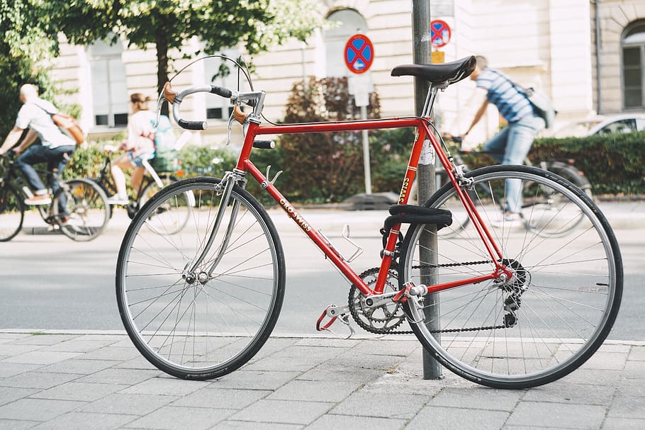 vermell, bicicleta, aparcat, al costat, publicació, paviment, carretera, acer, carrer, vehicle, transport, manera de transport, vehicle terrestre, ciutat, dia, signe, exterior de l'edifici, centrar-se en primer pla, estacionari, arquitectura, persones incidentals, estructura construïda, a l'aire lliure, comunicació, seguretat, vorera, vida de ciutat, roda, 5K