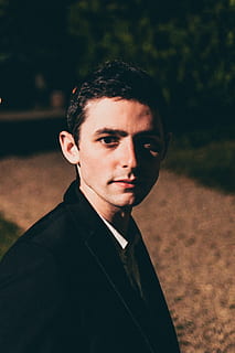 das Gesicht des Mannes, Mensch, Person, Gesicht, bekleidung, Kleidung, Mantel, passen, Mann, Künstler, Foto, Fotografie, Porträt, Menschen, Haut, Zubehörteil, Krawatte, Zubehör, Musikinstrument, Musiker, junger Erwachsener, Kamera betrachten, eine Person, junge Männer, Kopfschuss, Fokus auf den Vordergrund, echte Menschen, Lebensstile, Sonnenlicht, gut aussehend, Freizeitbeschäftigung, Feld, draußen, Vorderansicht, Natur, Land, Tag, Betrachtung, 4K, CC0, gemeinfrei, lizenzfrei