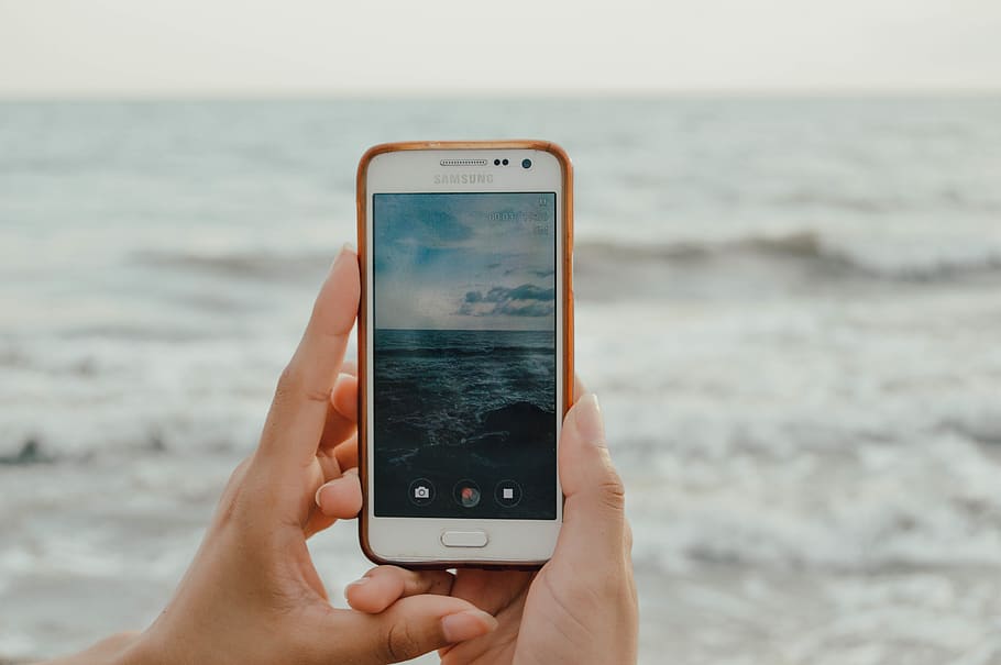persona, detenzione, smartphone, cattura, onde oceaniche, cellulare, elettronica, mani, macro, schermo, mare, scattare foto, tecnologia, mano umana, tecnologia wireless, mano, parte del corpo umano, dispositivo di informazione portatile, smart phone, comunicazione, persone reali, concentrarsi sulle conoscenze acquisite, acqua, una persona, stili di vita, telefono, connessione, schermo del dispositivo, all'aperto, dito, accessorio personale, 5K