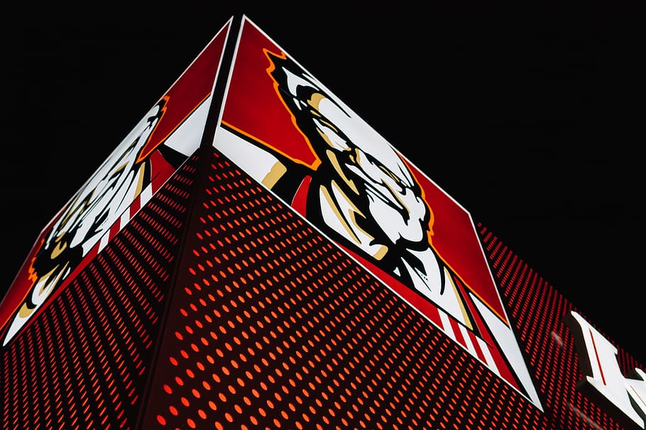 emblema kfc, logotip, marca comercial, símbol, bandera, llum, edifici, neó, signe, urbà, icònica, cartellera, vermell, kfc, cara, emblema, restaurant, carrer, nit, pollastre, menjar ràpid, vista d’angle baix, arquitectura, estructura construïda, cap gent, patró, exterior de l'edifici, il·luminat, cel, ciutat, forma, fons negre, naturalesa, modern, cel clar, a l'aire lliure, disseny, joc, luxe, gratacels, 5K