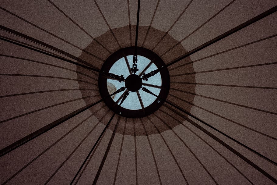 parasol marró, màquina, roda, arquitectura, edifici, finestra, tenda, forat, punt, equip, direcció, cercle, sostre, dimensió, línies, terrat, claraboia, cúpula, planta, torre, rellotge, patró, marc complet, cap gent, fons, dia, estructura construïda, vista d’angle baix, a l'interior, disseny, forma, forma geomètrica, directament a sota, llum solar, primer pla, naturalesa, seguretat, ornamentat, 5K
