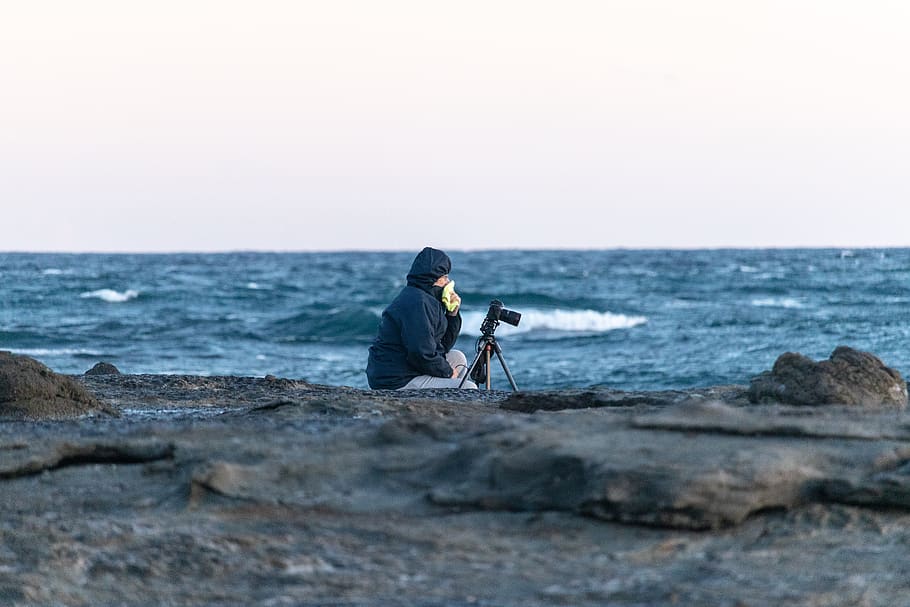 fotograf, Fotoaparát, stativ, oceán, fotografie, fotografování, technologie, zařízení, osoba, moře, voda, jedna osoba, horizont, horizont nad vodou, nebe, pláž, přistát, volnočasové aktivity, pevný, sedící, Skála, rock - objekt, Příroda, skutečných lidí, krása v přírodě, aktivita, selektivní zaměření, venku, kapuce - oblečení, teplé oblečení, 5K