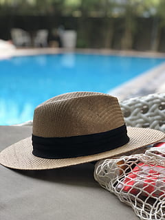 beige, black, hat, swimming, pool, accessory, poolside, recreation, swimming pool, water, wear, sun hat, focus on foreground, clothing, no people, day, close-up, straw hat, nature, still life, summer, sunlight, fashion, protection, outdoors, personal accessory, 4K, CC0, public domain, royalty free