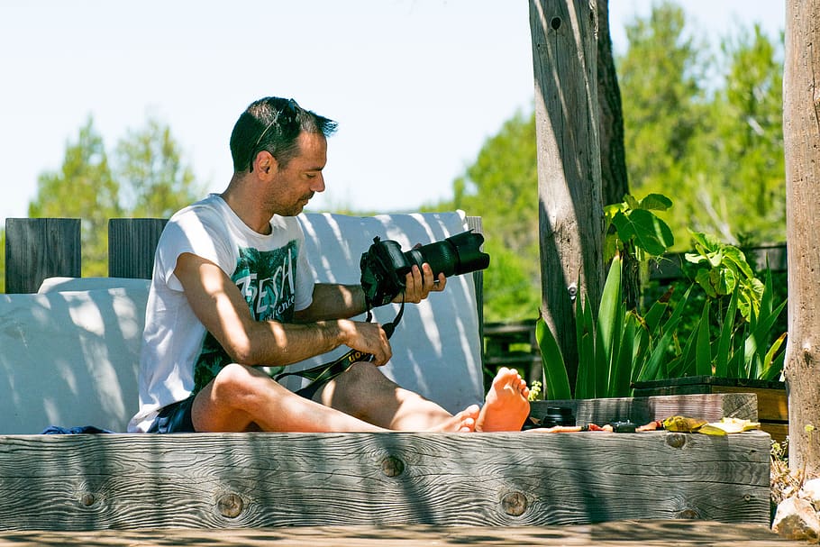 Mann, Sitzung, halten, DSLR-Kamera, Person, Mensch, Gewehr, Waffen, Waffe, Pflanze, bekleidung, Kleidung, kurze Hose, Foto, Fotografie, draußen, Mahlzeit, Lebensmittel, Fotograf, Baum, Wasser, Haut, Video spielen, Finger, eine Person, Tag, echte Menschen, Lebensstile, Legere Kleidung, Natur, Männer, Freizeitbeschäftigung, junger Erwachsener, junge Männer, Seitenansicht, Erwachsene, Sonnenlicht, Entspannung, Trinken, 5K