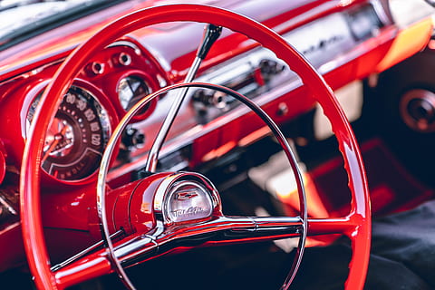 red steering wheel, vehicle, car, transportation, automobile, steering wheel, machine, classic cars, bel air, spoke, tire, wheel, alloy wheel, gauge, car wheel, tachometer, gearshift, motor, brake, jaguar car, windshield, mode of transportation, motor vehicle, land vehicle, red, vintage car, close-up, no people, retro styled, dashboard, control panel, focus on foreground, metal, day, outdoors, speedometer, antique, chrome, 8K, CC0, public domain, royalty free