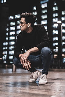 mand squat sidder, beklædning, tøj, person, human, fodtøj, sko, sneaker, ærme, langærmet, løbesko, mode, dating, menneskemængde, ruskind, ankel, høj hæl, sidder, støvle, bukser, publikum, en person, livsstil, unge mænd, fuld længde, rigtige mennesker, afslappet tøj, fritidsaktivitet, ung voksen, indendørs, fokus på forgrunden, leder, herrer, forfra, arkitektur, sund livsstil, kigger væk, overvejelse, 8K, CC0, offentligt domæne, royaltyfrie