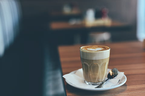 Kaffee, Cafe, Holz, heiß, Becher, Tasse, Weiß, Kaffeemaschine, Geschäft, Restaurant, Kunst, Design, Löffel, Teller, Serviette, Gewebe, Essen und Trinken, Kaffee trinken, Getränk, Erfrischung, Untertasse, Tabelle, Geschirr, Fokus auf den Vordergrund, Essgeschirr, Kaffeetasse, Küchenutensilien, drinnen, Frische, Stillleben, Glas, schaumiges Getränk, keine Leute, heisses Getränk, Latté, Café, 5K, CC0, gemeinfrei, lizenzfrei