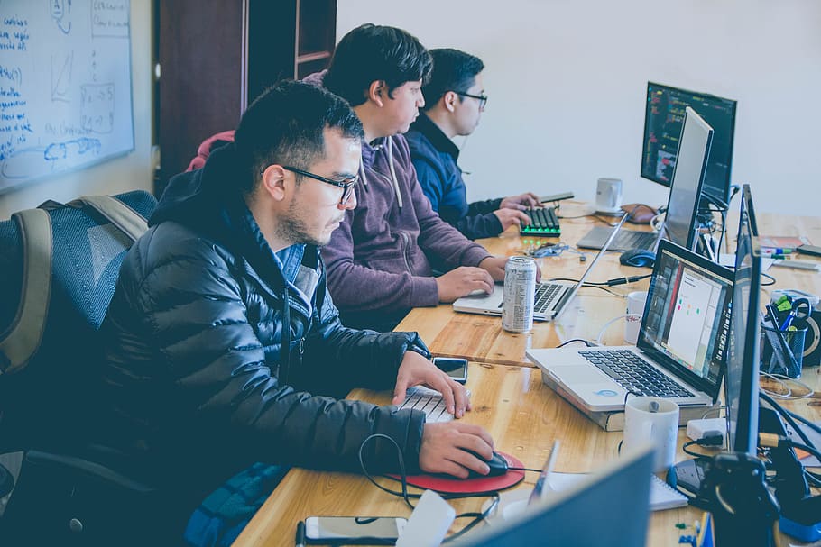 tre, uomini, di fronte, monitor per computer, computer, tavolo, seduta, comunicazione, tecnologia, giovani uomini, persone reali, tecnologia wireless, connessione, giovane adulto, scrivania, mobilia, lavoro, abbigliamento casual, vista laterale, attività commerciale, adulto, attrezzatura informatica, in casa, schermo del computer, usando il portatile, tastiera, 5K