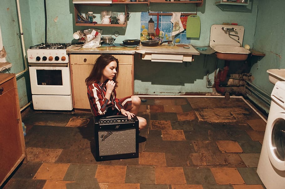 niña, sentado, junto a, gris, negro, amplificador de guitarra fender, dentro, habitación, amplificador, adentro, cocina, lavandería, horno, persona, asiento, lavabo, sentar, estufa, vestir, mujer, una persona, gente real, estilos de vida, ropa casual, adulto joven, longitud total, vista frontal, cuarto doméstico, mujer joven, retrato, actividad de ocio, adulto, en pie, silla, peinado, 2K