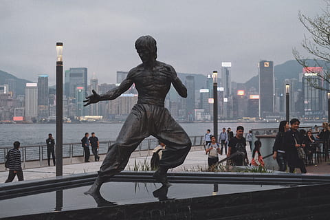 bruce lee statue, grup de persones, arquitectura, persones reals, ciutat, estructura construïda, exterior de l'edifici, homes, cel, naturalesa, estils de vida, multitud, gran grup de persones, activitat d'oci, vida de ciutat, dones, aigua, art i artesania, escultura, barana, paisatge urbà, a l'aire lliure, exterior d’edifici d’oficines, gratacels, 5K, CC0, domini públic, lliure de regalies