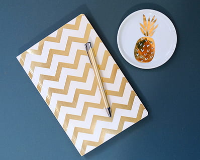 hvid, guld chevron notesbog, design, notesbog, notesblok, mønster, pen, ananas, indendørs, mad og drikke, ingen mennesker, høj vinkel visning, mad, studio skud, stilleben, tæt på, direkte over, arkitektur, bakke, bord, form, plade, grå, geometrisk form, orange farve, friskhed, 2K, CC0, offentligt domæne, royaltyfrie