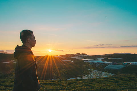 Foto, mand, solopgang, daggry, dagslys, skumring, græs, hættetrøje, landskab, person, sidebillede, himmel, rejse, udsigt, have på, solnedgang, en person, sollys, skønhed i naturen, natur, linseflare, stående, fritidsaktivitet, Mark, rigtige mennesker, orange farve, sol, livsstil, ung voksen, jord, scenics - natur, voksen, udendørs, 4K, CC0, offentligt domæne, royaltyfrie