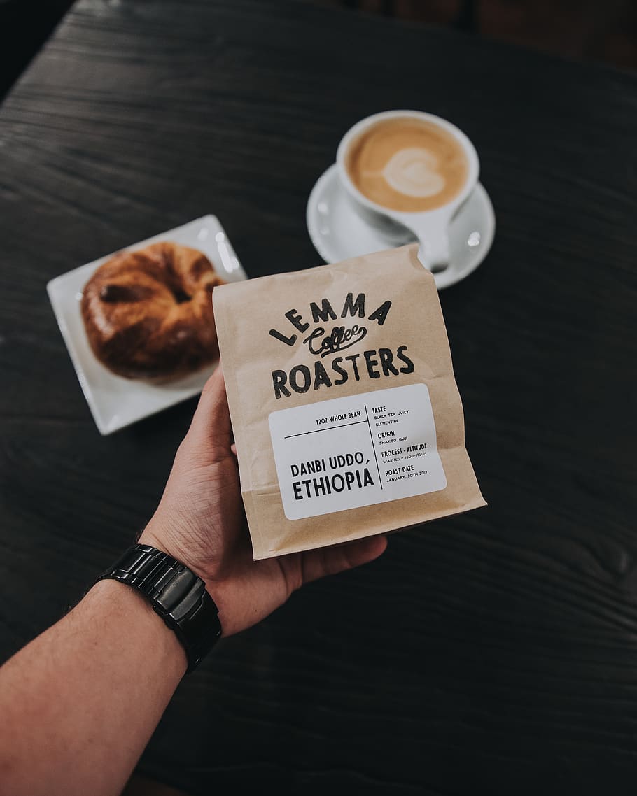 paquet de torradores de lemma, tassa de cafè, tassa, rellotge de polsera, persona, humà, latte, cafeteria, ceràmica, plat, ou, menjar, beure, begudes, espresso, estètic, cafè, restaurant, pa, bun, croissant, mà humana, mà, celebració, part del cos humà, una persona, persones reals, menjar i beguda, vista d’angle alt, paper, persona irreconeixible, text, estils de vida, cafè - beguda, perspectiva personal, comunicació, dit, 4K