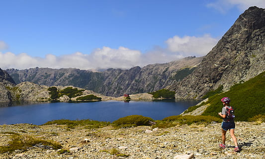 Person, Stehen, See, wolkig, Himmel, Höhe, Rucksack, Wolken, Tageslicht, Gras, Helm, hoch, Wanderung, Landschaft, Gipfel, Berge, Natur, draußen, Felsen, szenisch, Wasser, Frau, Berg, Freizeitbeschäftigung, in voller Länge, Schönheit in der Natur, eine Person, Szenen - Natur, Rock, wolke - himmel, solide, Aktivität, Rock - Objekt, Lebensstile, Tag, Gebirge, 5K, CC0, gemeinfrei, lizenzfrei