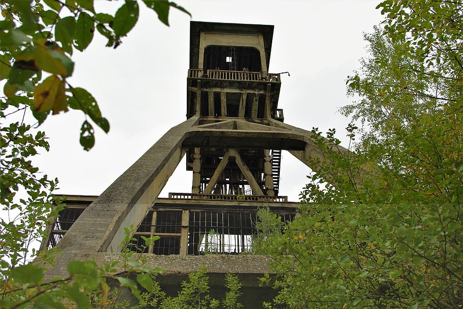 mining, industry, work, construction, architecture, factory, extraction, tree, plant, built structure, low angle view, building exterior, nature, building, sky, no people, day, tower, clear sky, green color, history, growth, outdoors, the past, religion, belief, clock, 2K