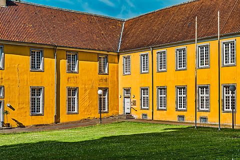building, facade, colourful, architecture, exterior, urban, yellow, bright, sunny, building exterior, built structure, grass, window, no people, residential district, day, nature, lawn, house, plant, outdoors, sky, sunlight, green color, city, roof, wall - building feature, 5K, CC0, public domain, royalty free