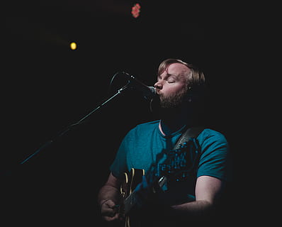 mand, sang, spille, guitar, mennesker, human, person, kunstner, musiker, musikinstrument, musikalsk, kunst, belysning, musik, scene, portræt, performer, ydeevne, udfører, mikrofon, scene lys, scene belysning, en person, input enhed, kunstkultur og underholdning, skæg, bedrift, sort baggrund, indendørs, sanger, ansigtshår, ung voksen, taljen op, voksen, studio skud, mørk, mikrofonstativ, rockmusik, 4K, CC0, offentligt domæne, royaltyfrie