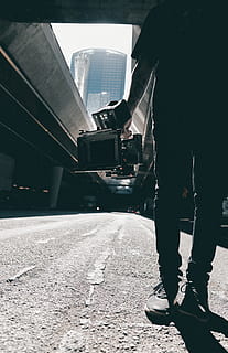 Menschen, Mann, Schatten, Kerl, Kamera, Video, Aufzeichnung, Schuhe, Kameramann, Fotograf, Film, Straße, Gebäude, Brücke, Autobahn, tätowieren, Kunst, Fahrzeuge, Transport, eine Person, echte Menschen, Stadt, niedriger Abschnitt, Stehen, Männer, menschliches Körperteil, Tag, Natur, die Architektur, menschliches Bein, Körperteil, Gebäudehülle, Sonnenlicht, gebaute Struktur, Schienenverkehr, Lebensstile, Transportmittel, warten, menschliches Glied, 5K, CC0, gemeinfrei, lizenzfrei